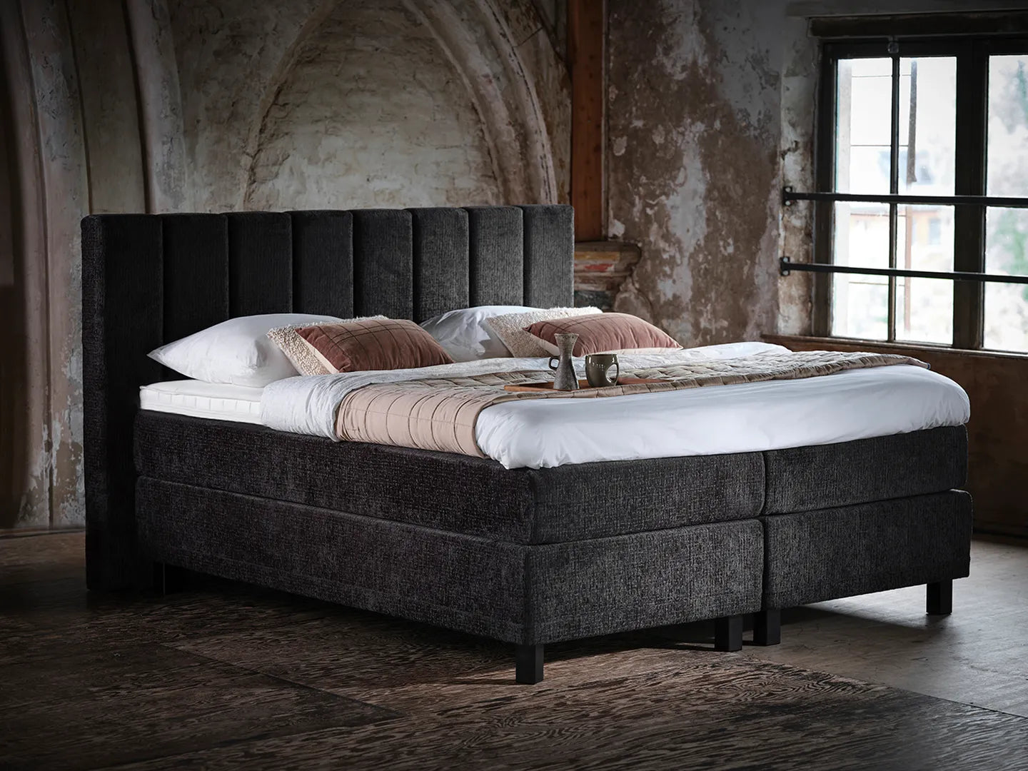 Pullman boxspring met gestoffeerd hoofdbord in sfeervolle slaapkamer