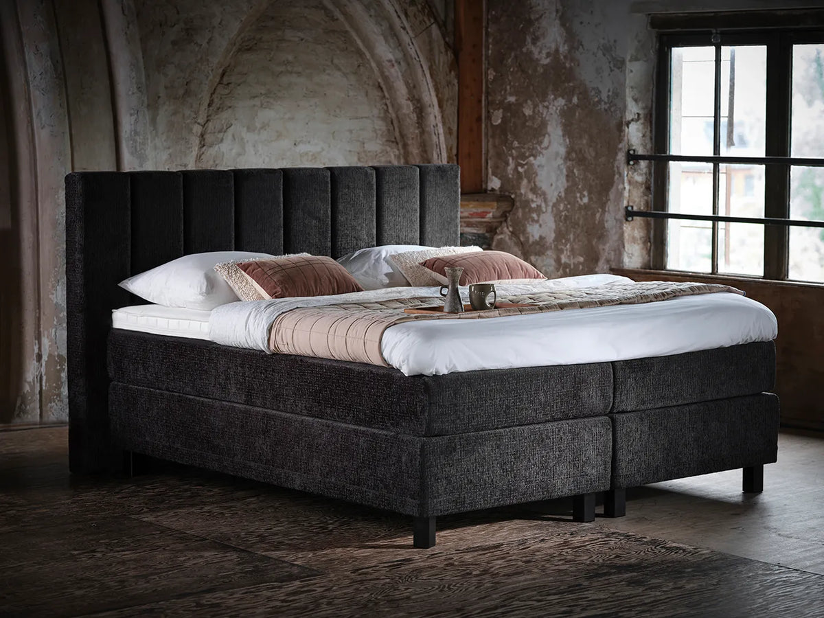 Pullman boxspring met gestoffeerd hoofdbord in sfeervolle slaapkamer