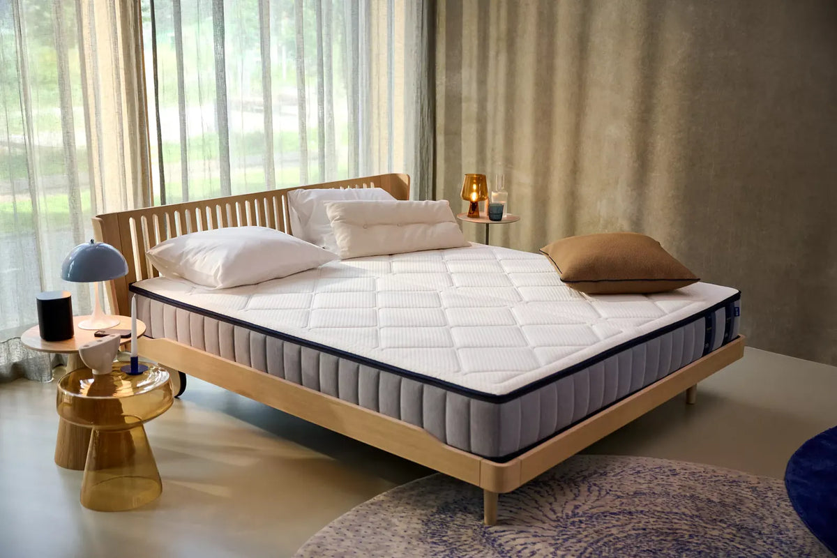 Auping Elysium matras op een houten bedframe in een lichte slaapkamer