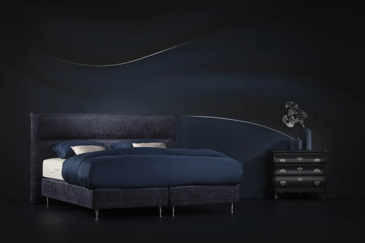 Opgemaakt Pullman bed met blauw beddengoed in een donker sfeerdecor