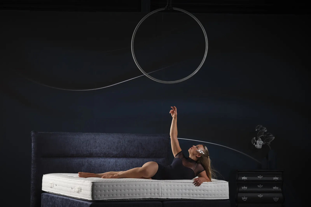 Vrouw ligt uitgestrekt op een Pullman Silverline matras op een boxspring