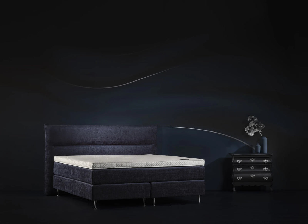 Pullman Silverline topper op een donkerblauwe boxspring met hoofdbord en nachtkastje
