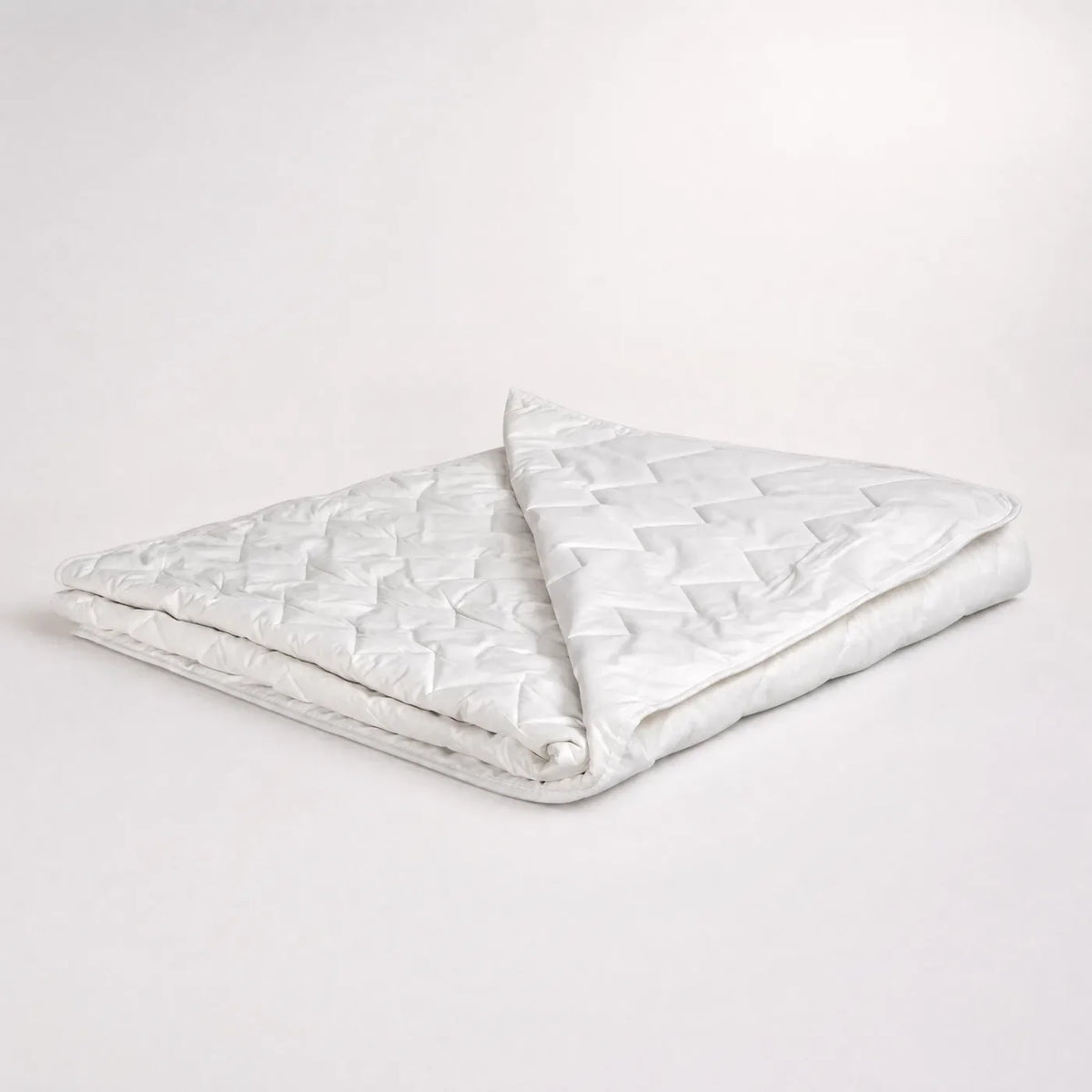 Tencel zomerdekbed AeroFresh opgevouwen op een witte achtergrond