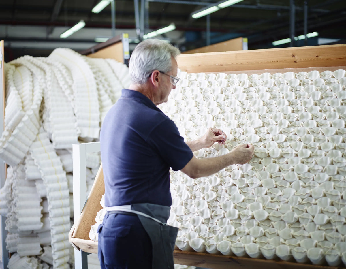 Vakman die calico pocketveren met de hand in een honingraatpatroon nest